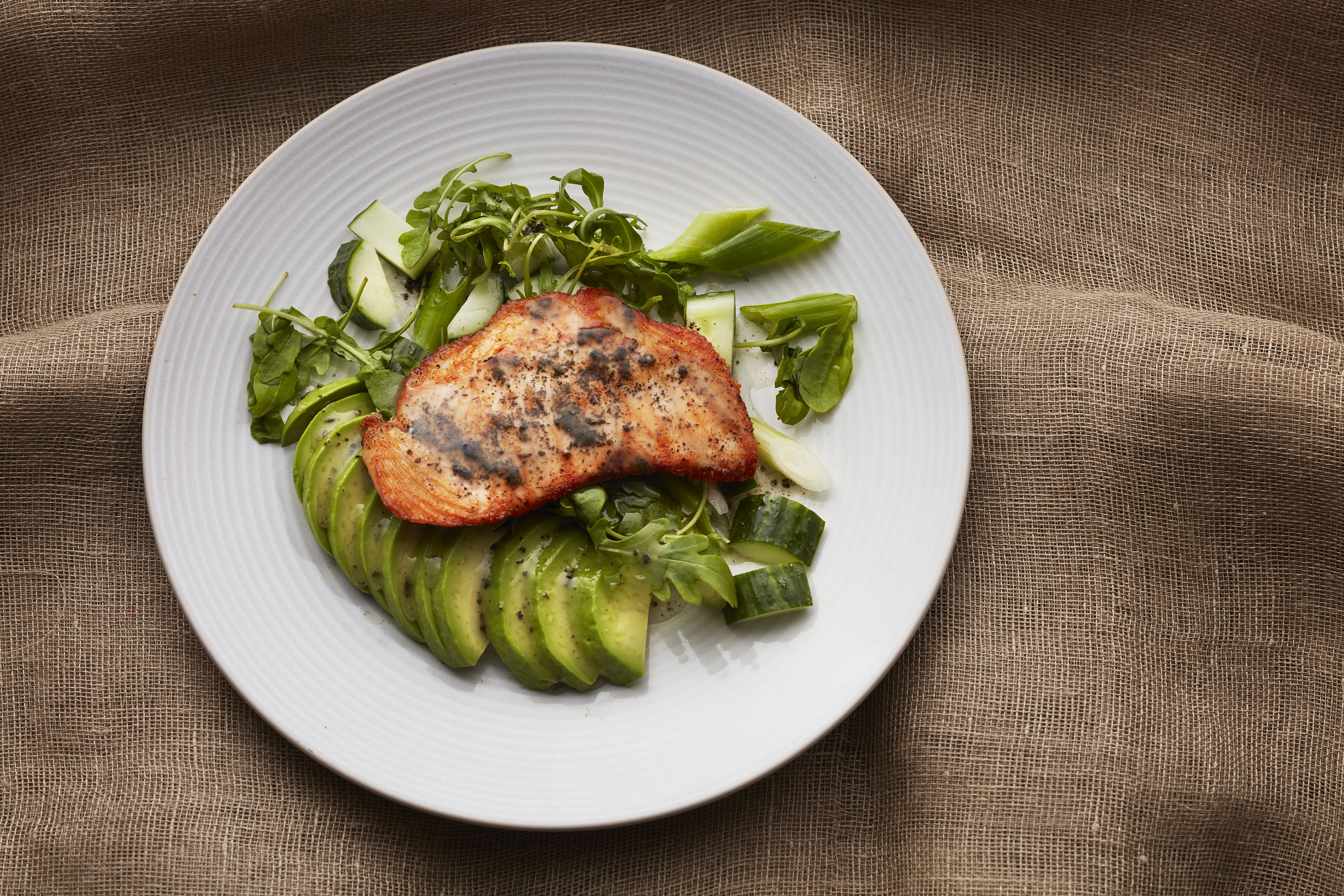 Lohipala lautasella avokadolla ja valkosipulilla