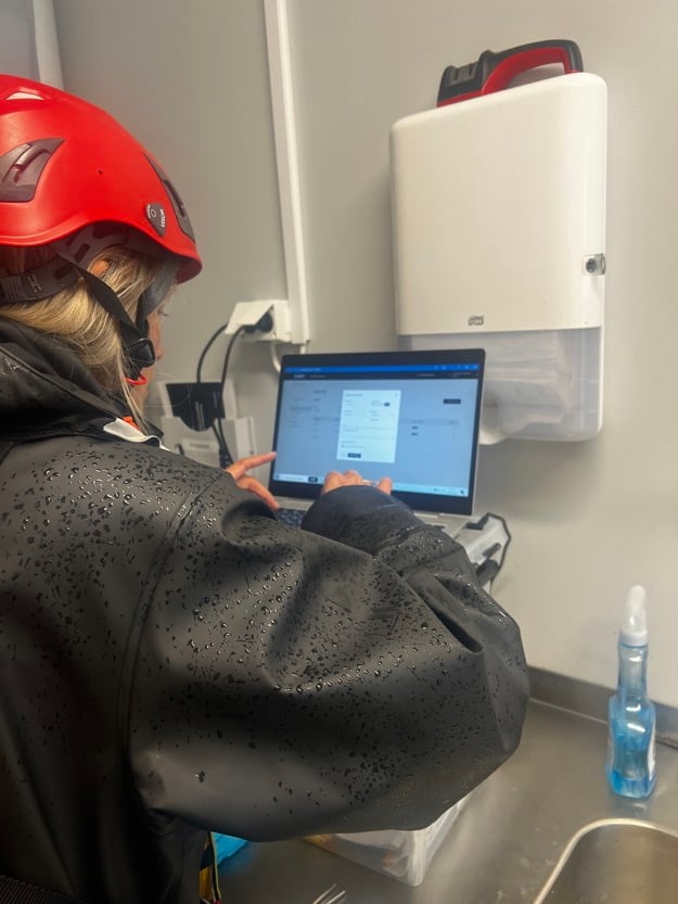 En kvinne sett bakfra med en skjerm foran seg. 