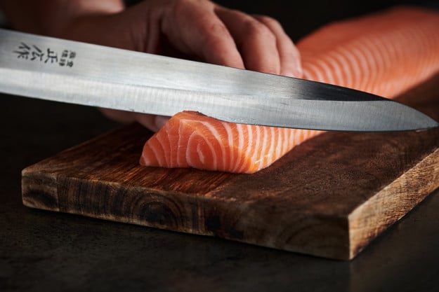 En loin av laks som skjæres med en skarp kniv