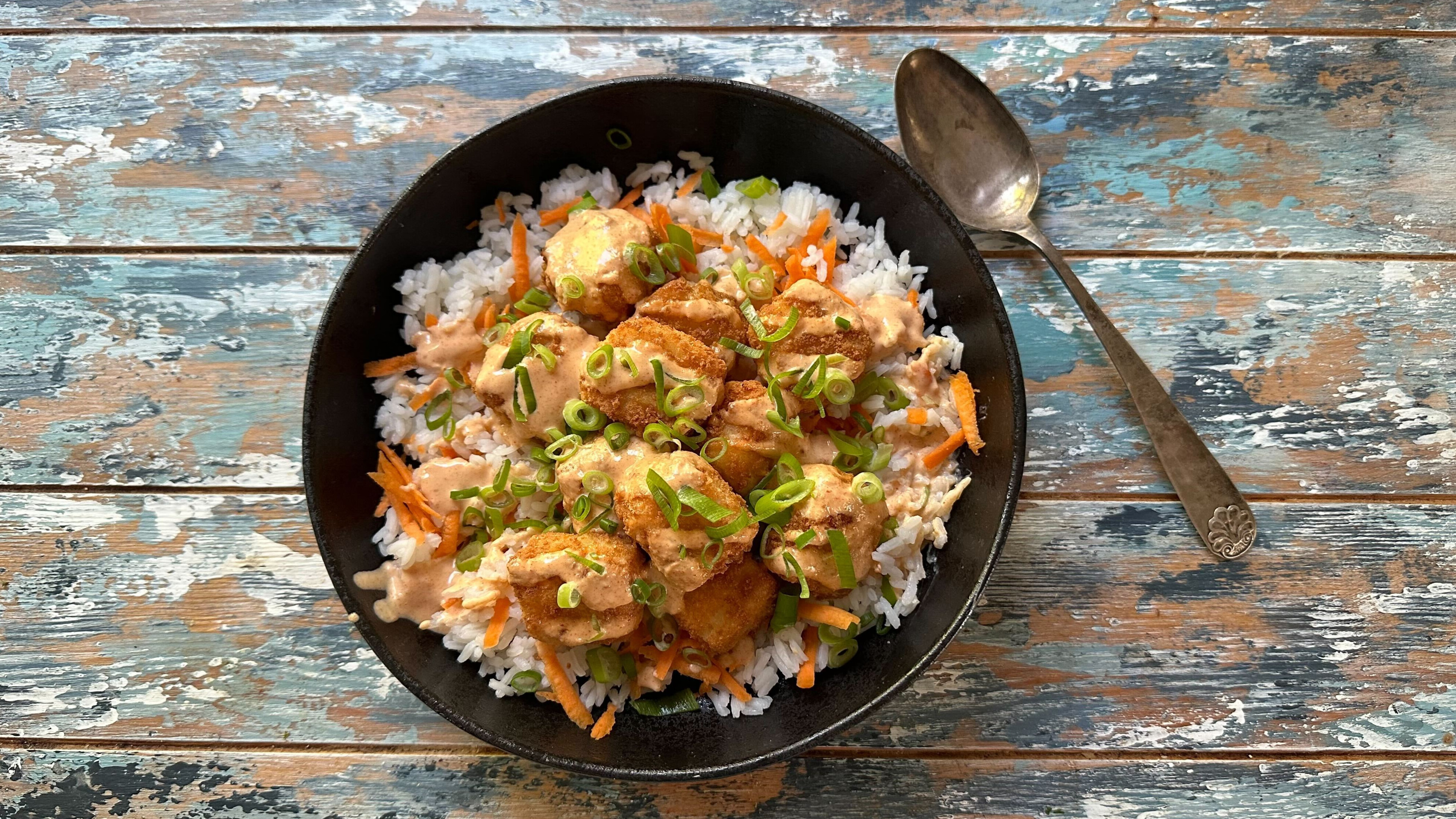 En skål på et bord med Ssprøpanerte torsketerninger med chipotlemajones